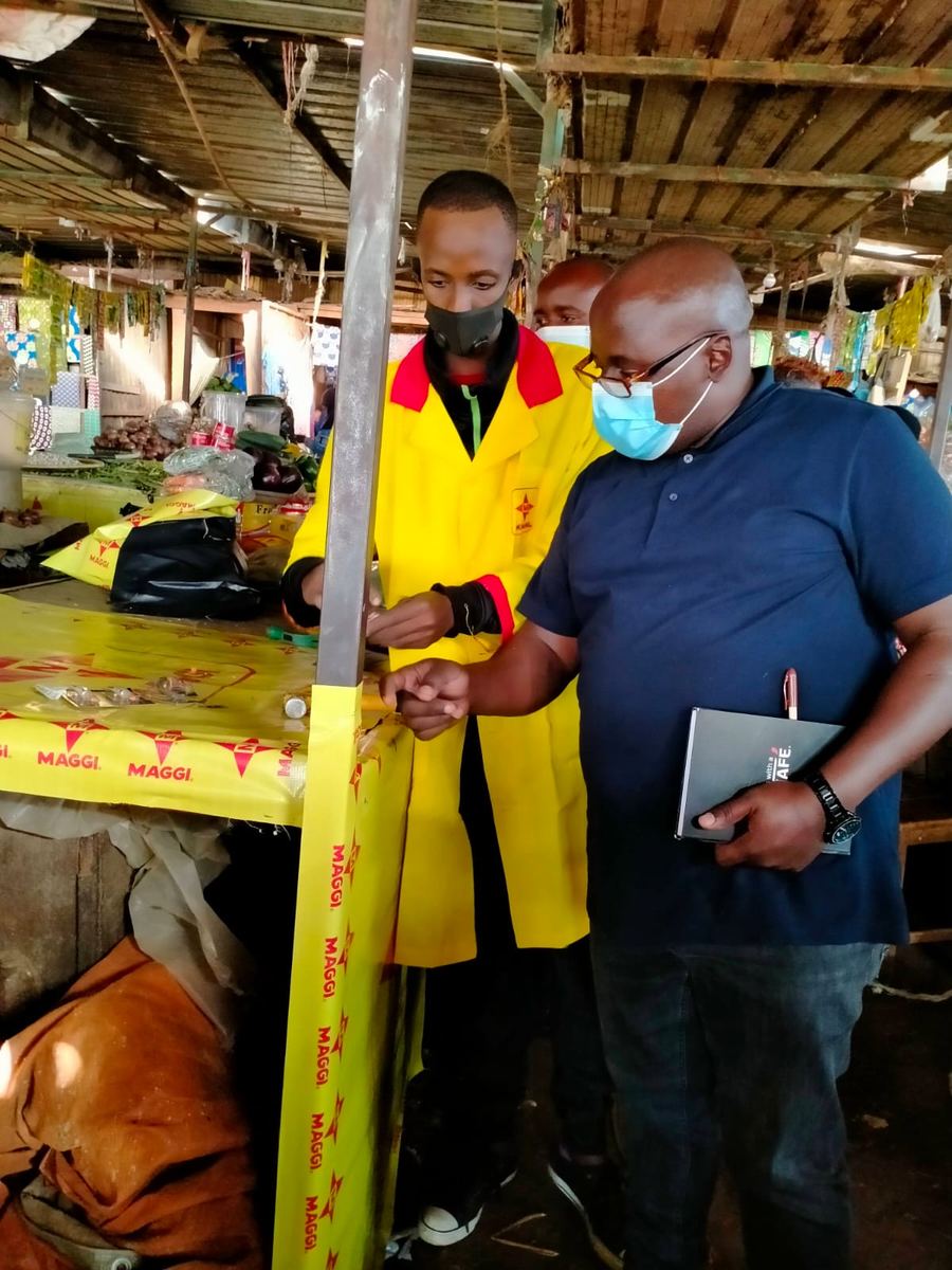 A market stall table being dressed in yellow MAGGI branding during a field visit